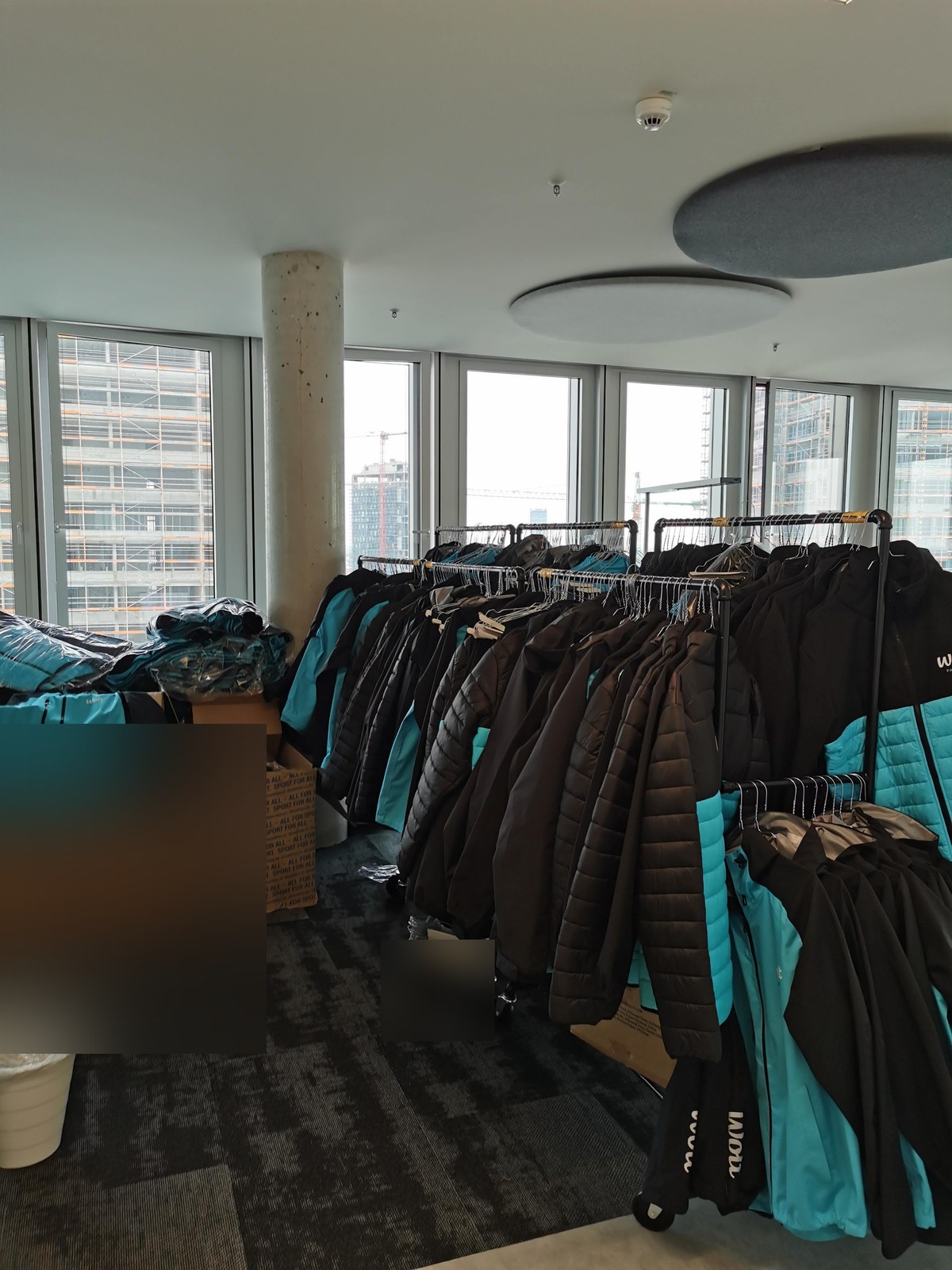 Rows of Wolt courier jackets hanging on rails at the Berlin office, sorted and ready for re-issue.